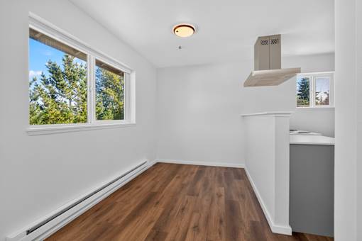 A room with a window and a wooden floor.
