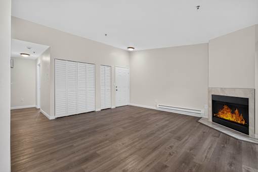 A room with a fireplace and wooden flooring.