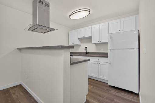 A newly remodeled kitchen with white cabinets and grey quartz countertops at Ridgeline Apartments