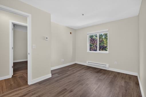 A room with a window and a picture on the wall.