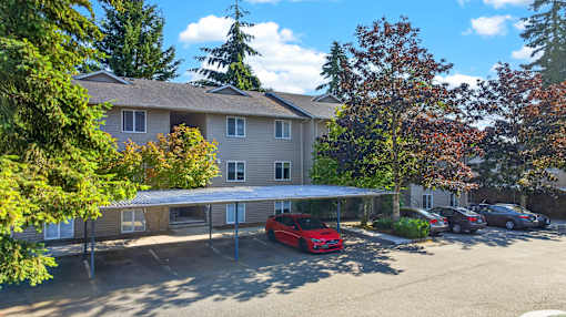 A red car is parked in front of a building.