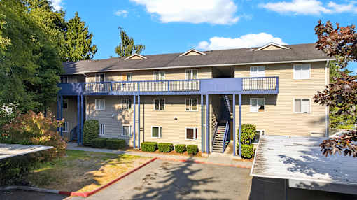 A large apartment building with a red driveway in front.