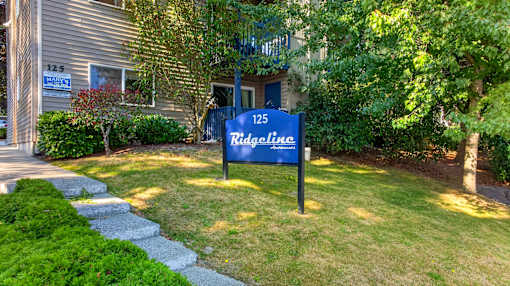 A blue sign that says Ridgeline in front of a house.