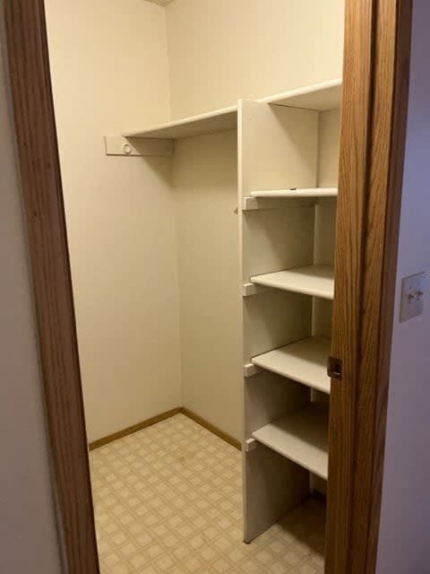 A white closet with shelves and a door.
