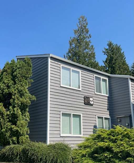 A grey house with a darker grey roof and a small window on the front.