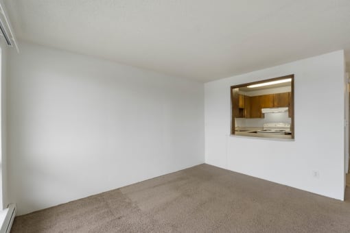 an empty living room with white walls and a window