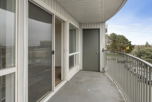 the view from the balcony of a home with a large screen door to the patio