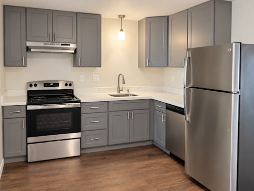 A modern kitchen with a stainless steel refrigerator and oven.