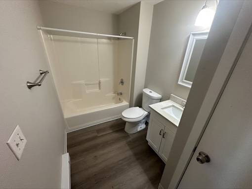 A white bathroom with a toilet, sink, and bathtub.