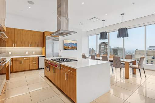A modern kitchen with a large island and a view of the city.