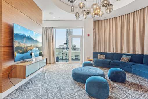A modern living room with a large screen TV and comfortable seating.