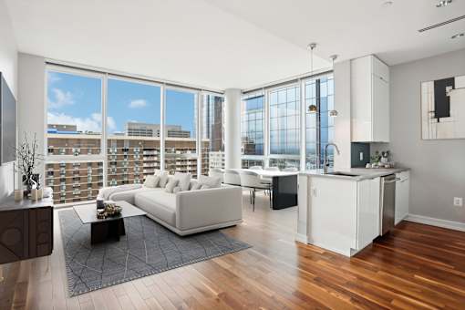 A living room with a white couch and a coffee table in front of a large window.