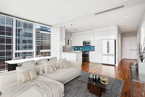 A modern living room with a white sofa and a glass table.