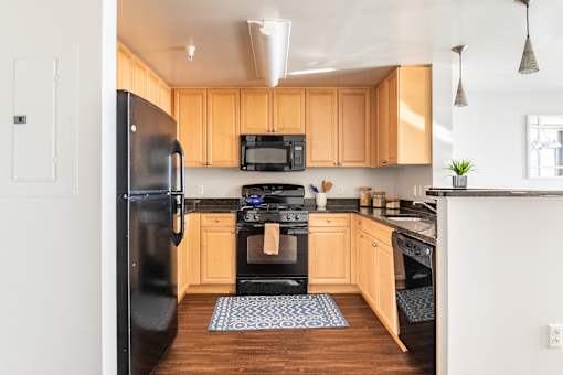A kitchen with wooden cabinets and black appliances.