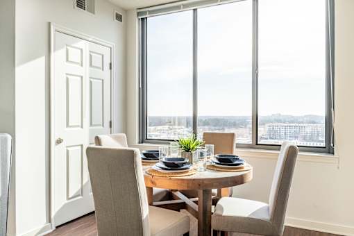 A dining room with a table set for two and a view of the city.