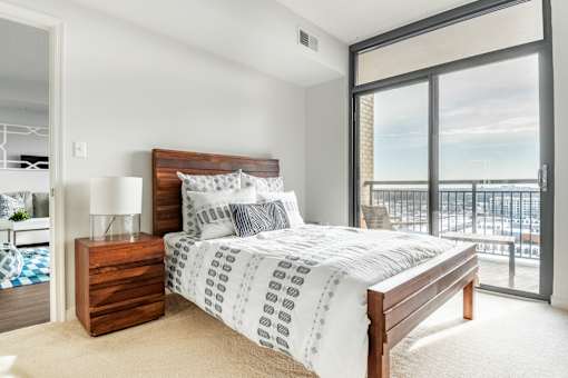 A bedroom with a large bed and a view of the city.