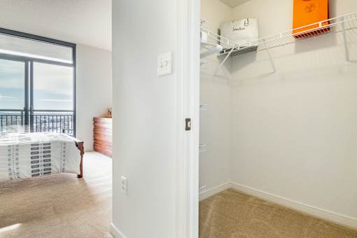 A bedroom with a bed and a balcony.