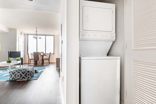 A white refrigerator is in a kitchen next to a dining room.