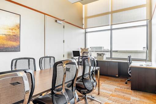 A conference room with a long table and chairs.
