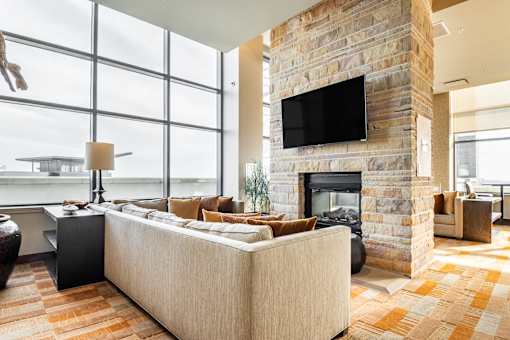 A living room with a stone fireplace and a large couch.