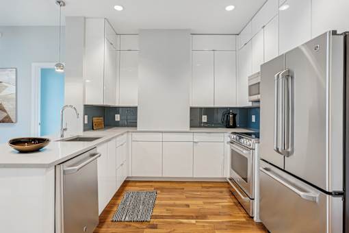 A modern kitchen with stainless steel appliances and white cabinets.