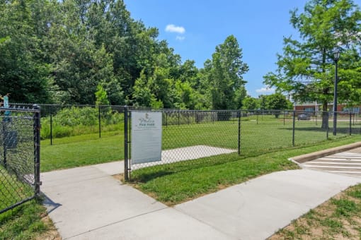 a fenced in dog park with trees in the background at The Madison of Tyler Apartment Homes, Tyler