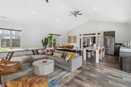 A modern living room with a grey couch and a round ottoman. at Highland Village, Ross Township, Pittsburgh, PA 15229