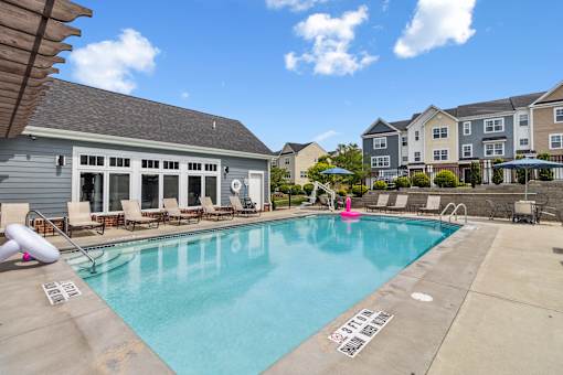 A swimming pool with a slide and a building in the background. at Highland Village, Ross Township, Pittsburgh, PA 15229