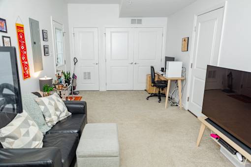 A living room with a black couch and a television. at Highland Village, Ross Township, Pittsburgh, PA 15229