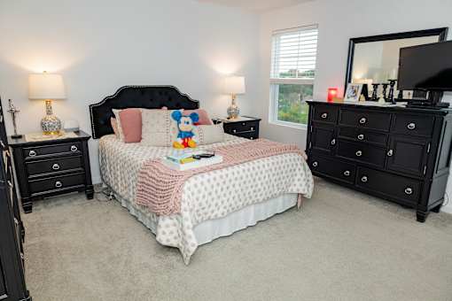 A bedroom with a bed, dresser, and mirror. at Highland Village, Ross Township, Pittsburgh, PA 15229