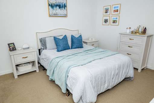 A bedroom with a bed, nightstand, and a painting on the wall. at Highland Village, Ross Township, Pittsburgh, PA 15229