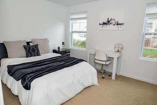 A bedroom with a large bed and a desk. at Highland Village, Ross Township, Pittsburgh, PA 15229