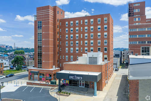 A large red brick building with a Jones Tower sign in front.at The Jones Tower at the Collective, Pittsburgh, PA 15203