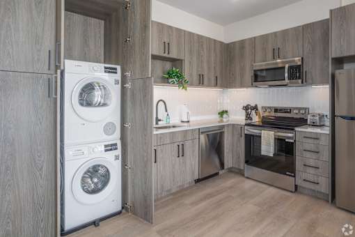 A modern kitchen with a washing machine built into the cabinetry.at The Jones Tower at the Collective, Pittsburgh, PA 15203