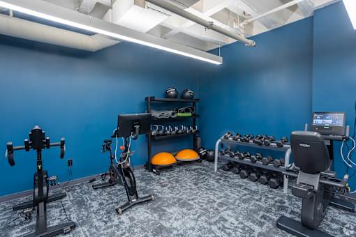 A gym with a blue wall and a variety of exercise equipment.at The Jones Tower at the Collective, Pittsburgh, PA 15203