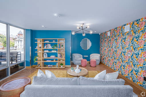 A living room with a grey couch and a blue wall.at The Jones Tower at the Collective, Pittsburgh, PA 15203