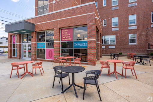 A brick building with tables and chairs in front.at The Jones Tower at the Collective, Pittsburgh, PA 15203