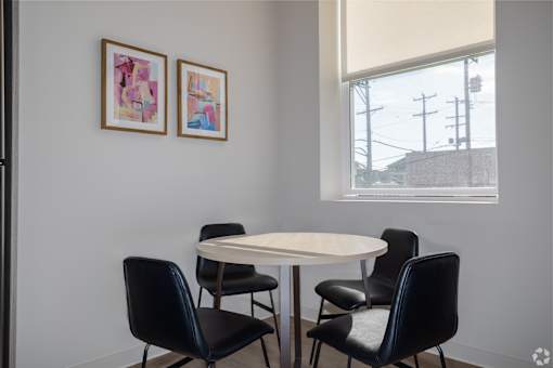 A white table with four chairs in front of a window.at The Jones Tower at the Collective, Pittsburgh, PA 15203