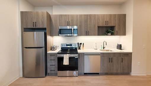A modern kitchen with a stainless steel refrigerator and a black oven.at The Jones Tower at the Collective, Pittsburgh, PA 15203