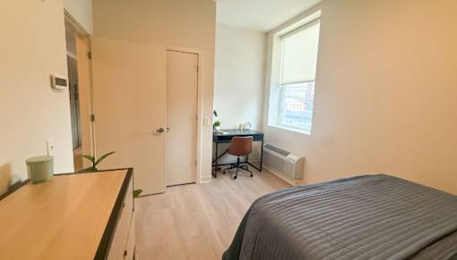 A room with a bed, desk, and chair.at The Jones Tower at the Collective, Pittsburgh, PA 15203