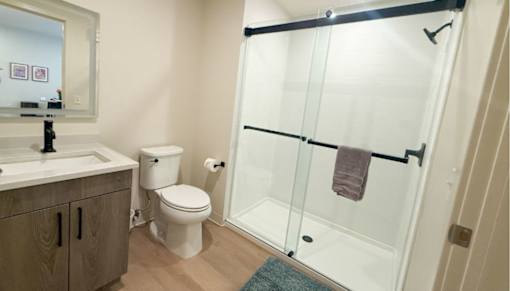 A bathroom with a toilet, sink, and shower.at The Jones Tower at the Collective, Pittsburgh, PA 15203