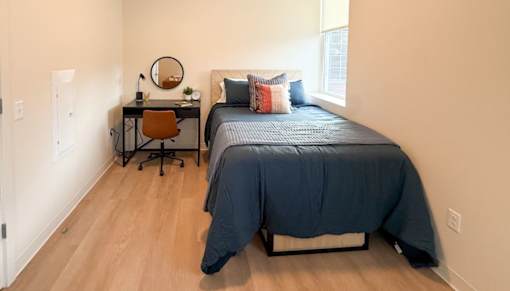 A bedroom with a bed, desk, and chair.at The Jones Tower at the Collective, Pittsburgh, PA 15203