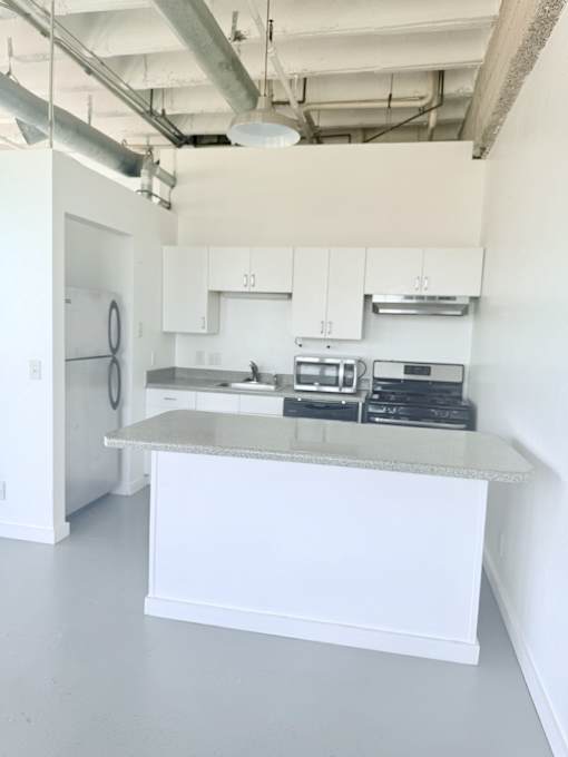 A kitchen with white cabinets and a countertop.