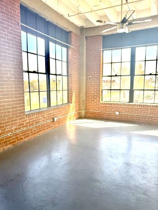 A room with a concrete floor and brick walls.