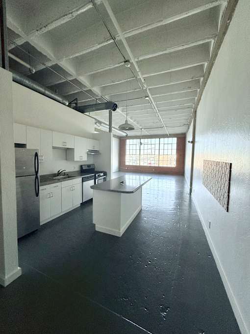 A kitchen with black floors and white cabinets.