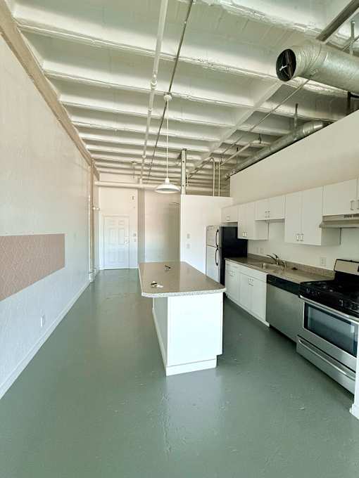 A kitchen with white cabinets and a stainless steel oven.