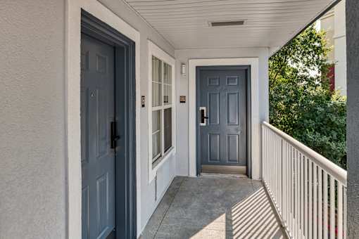 the front door of a house with blue doors and a porch