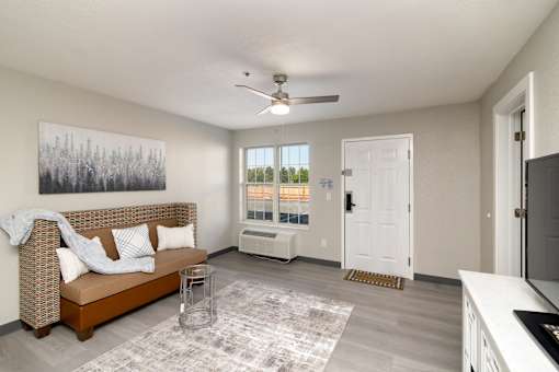an open living room with a couch and a ceiling fan