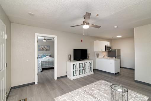 an open living room and kitchen with a bedroom in the background