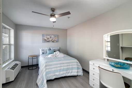 a bedroom with a bed and a ceiling fan